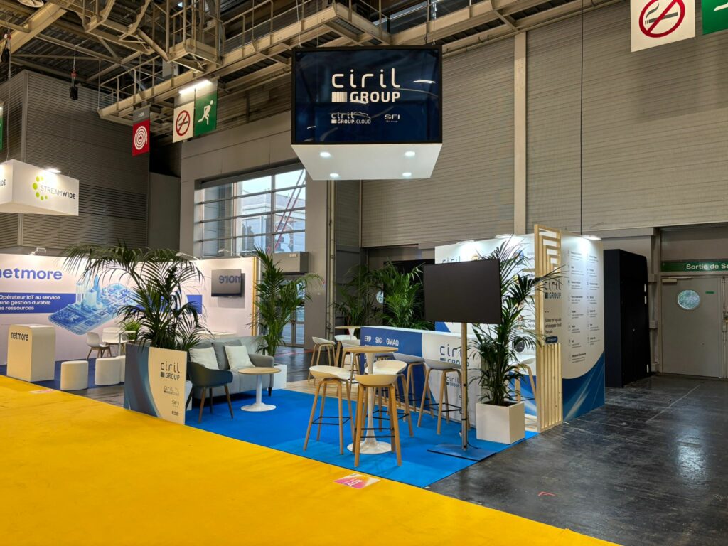 Vue d’ensemble du stand Ciril Group au Salon des Maires, avec sol bleu et signalétique suspendue.
