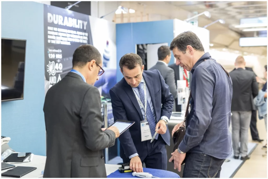 Fabricant de stand Paris échangeant avec des exposants lors d’un salon professionnel