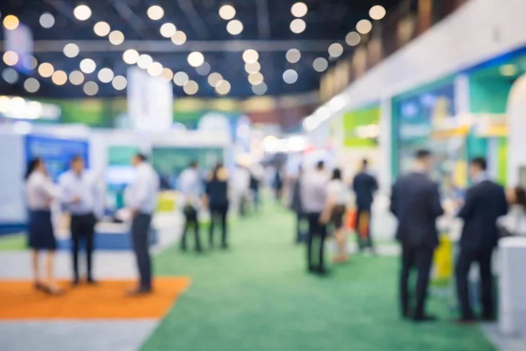 Allée de salon professionnel avec stands modulaires et visiteurs